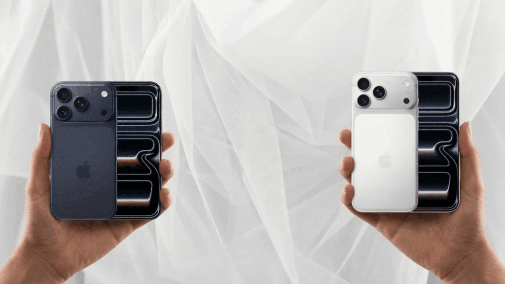 hands holding iPhone 17 Pro and iPhone 17 Pro Max side by side showing rear triple cameras and front displays for size comparison.