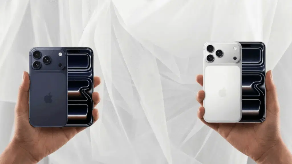 hands holding iPhone 17 Pro and iPhone 17 Pro Max side by side showing rear triple cameras and front displays for size comparison.