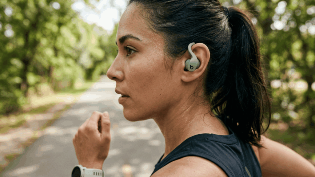 person wearing Beats Fit Pro earbuds while running outdoors, showing secure fit and workout use