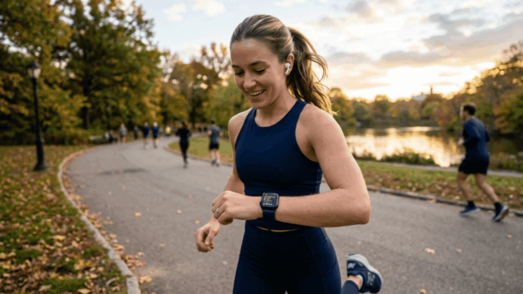 woman jogging in park wearing Apple Watch, checking fitness stats during workout with scenic outdoor running environment