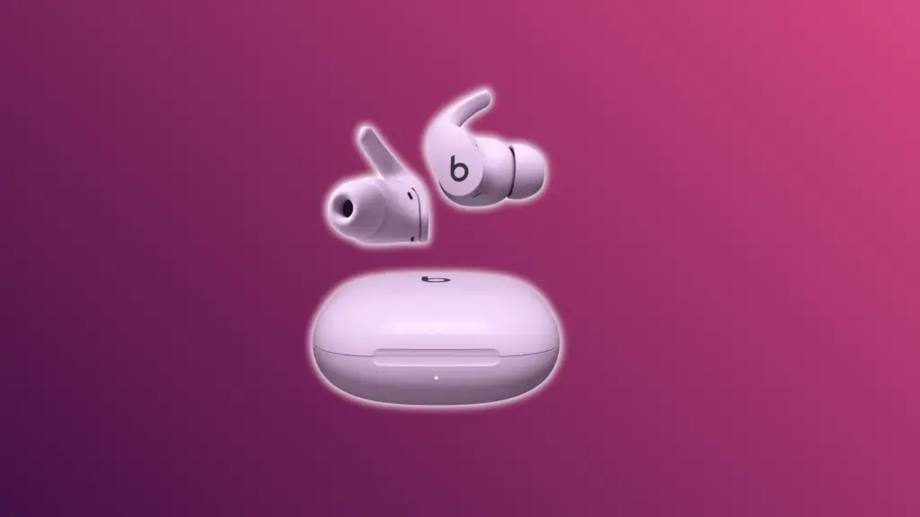 Beats Fit Pro earbuds with charging case on a pink background.