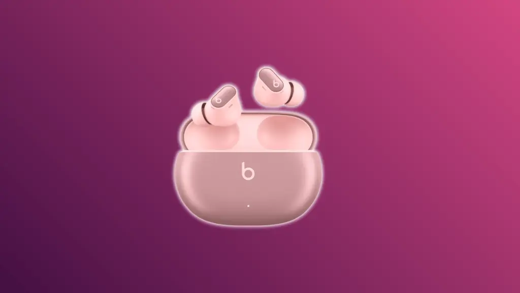 Beats Studio Buds Plus earbuds with charging case on a pink background.