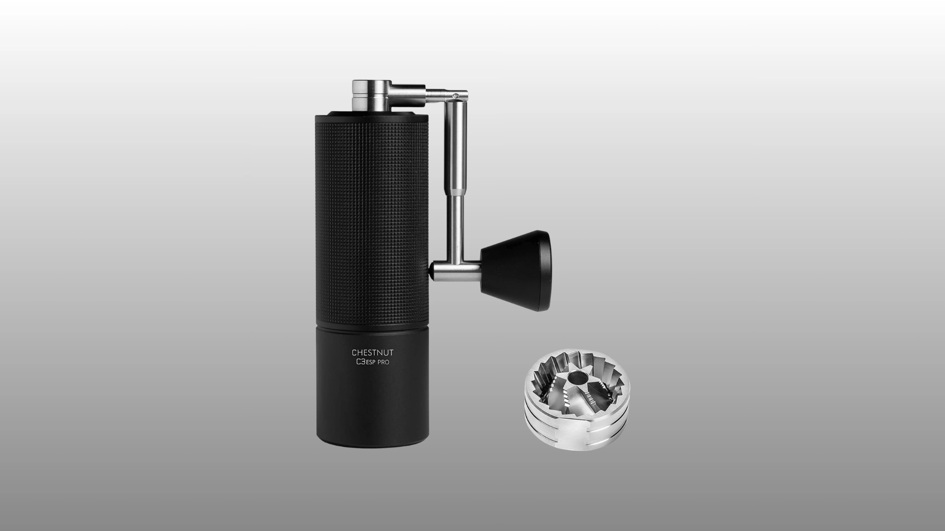 Black manual coffee grinder with side handle and separate metal burr piece.