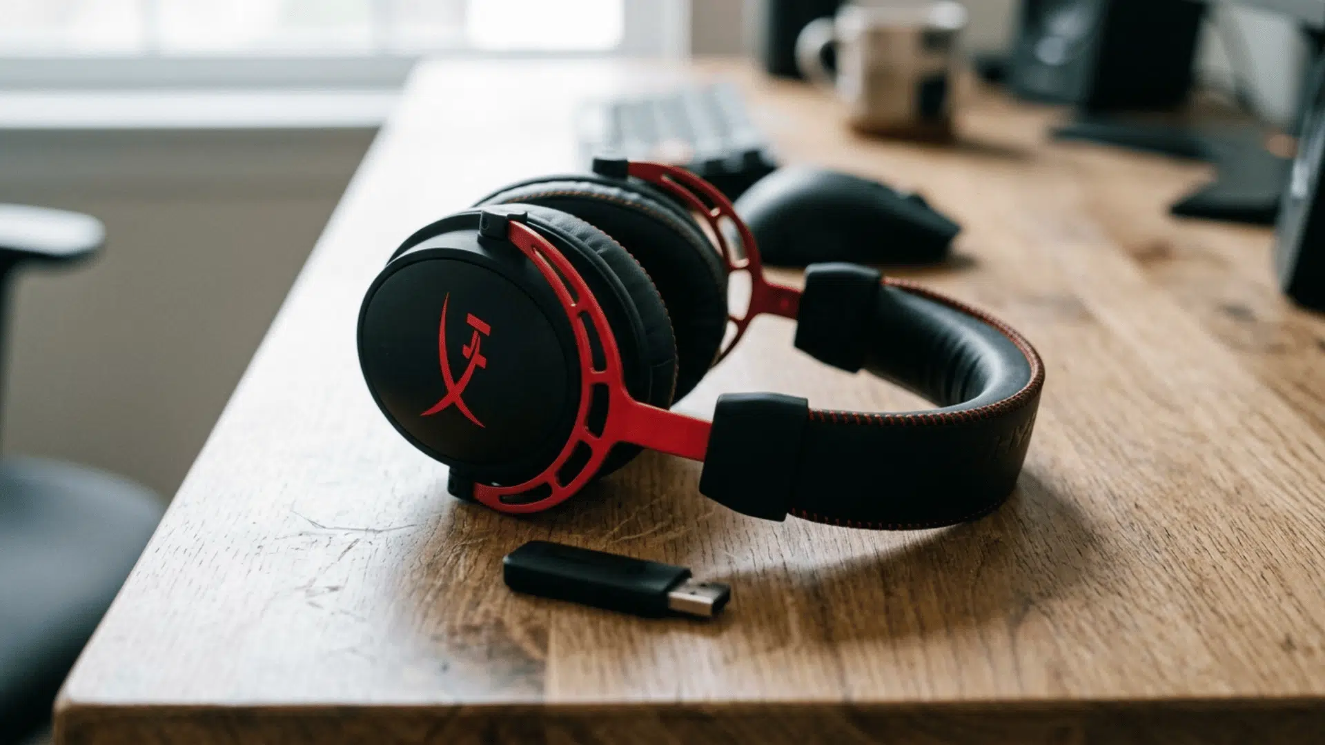 hyperX gaming headset with red accents placed on desk, highlighting build quality and wireless USB dongle for gaming use