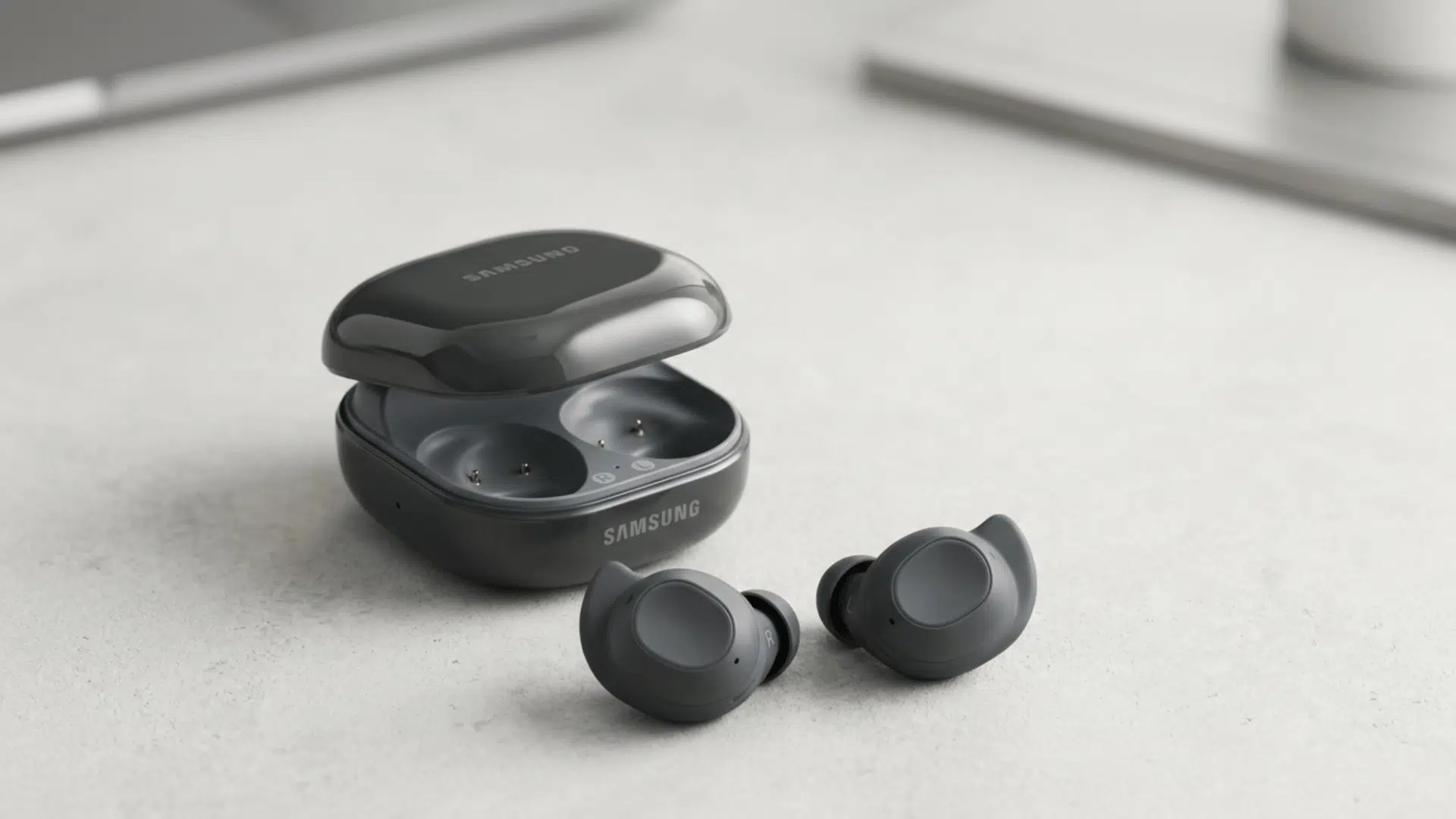 samsung Galaxy Buds FE earbuds placed beside an open charging case, showing compact design and true wireless earbud setup.