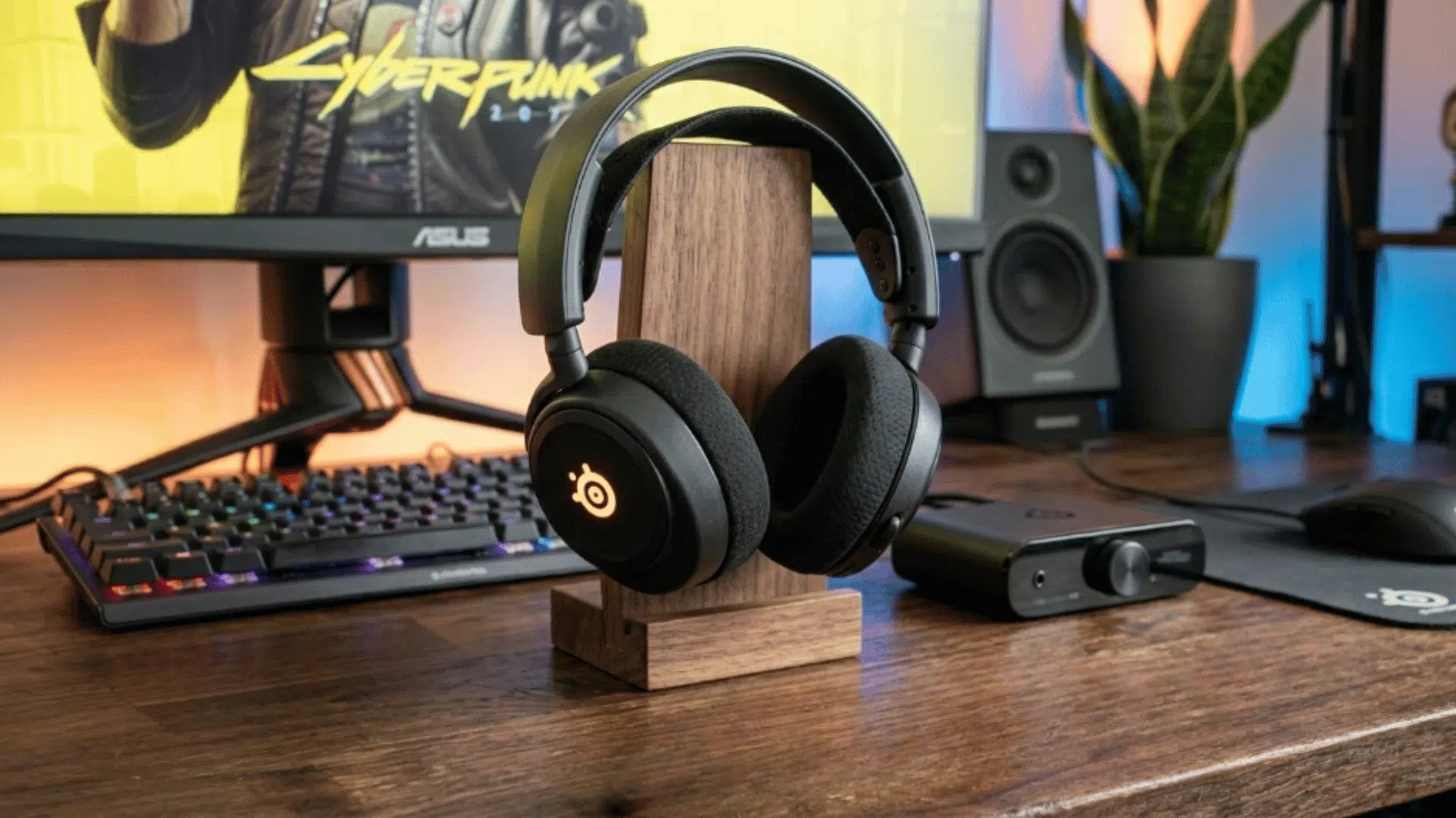 steelseries wireless gaming headset placed on desk setup with keyboard and monitor, showing clean gaming workspace and audio gear (1)
