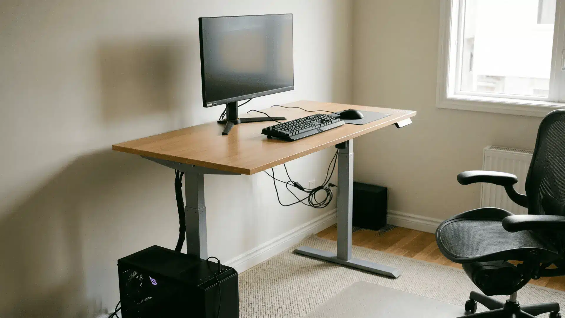 Adjustable standing desk raised with monitor and peripherals arranged for standing use