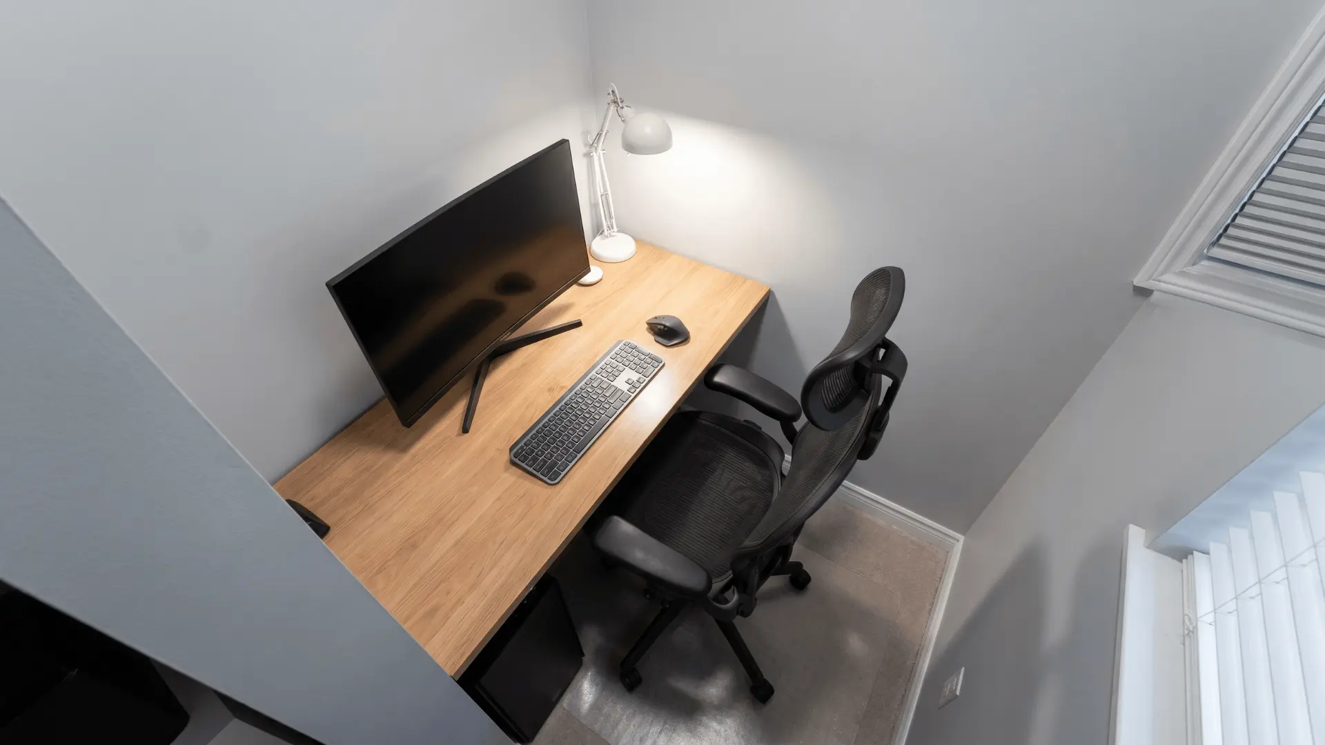 Desk placed between two walls with monitor angled toward the center