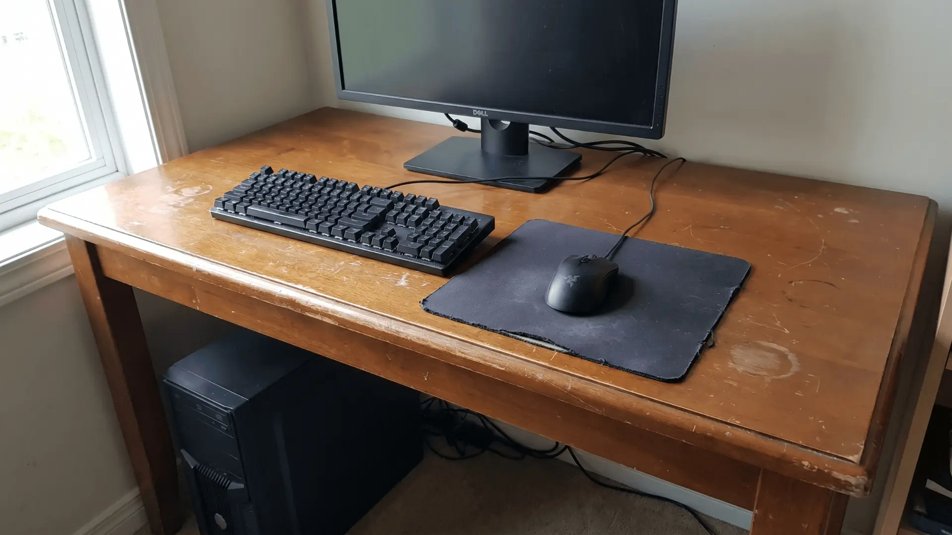 Gaming setup on a used desk with minor surface wear and stable structure