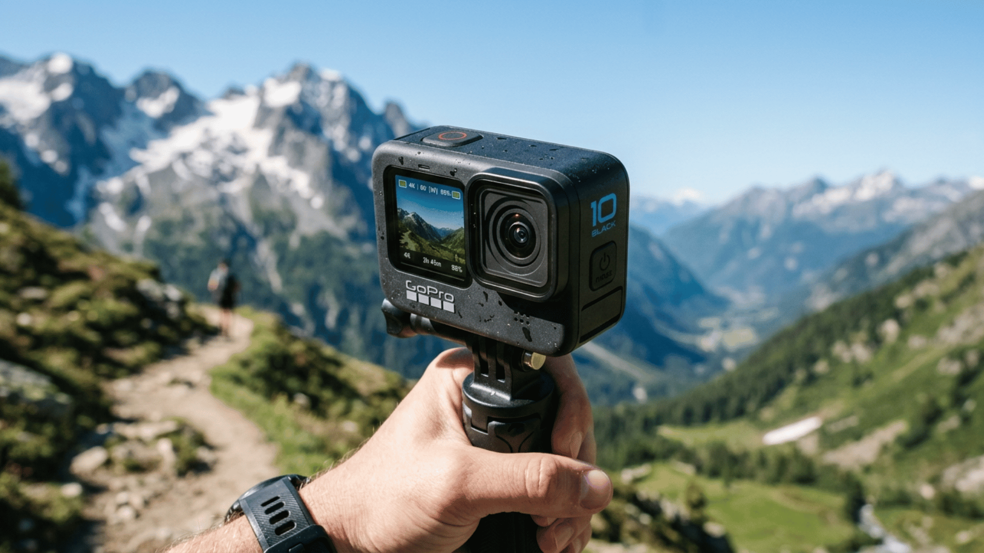 go pro Hero 10 Black held on grip in mountain setting, perfect for action shots, travel videos, and handheld recording