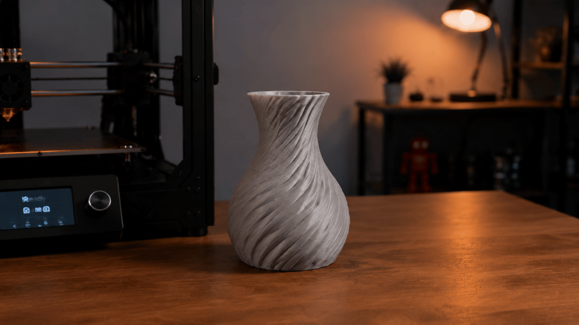 a 3d printing workspace showing a finished printed vase in indoor setting studio light setup