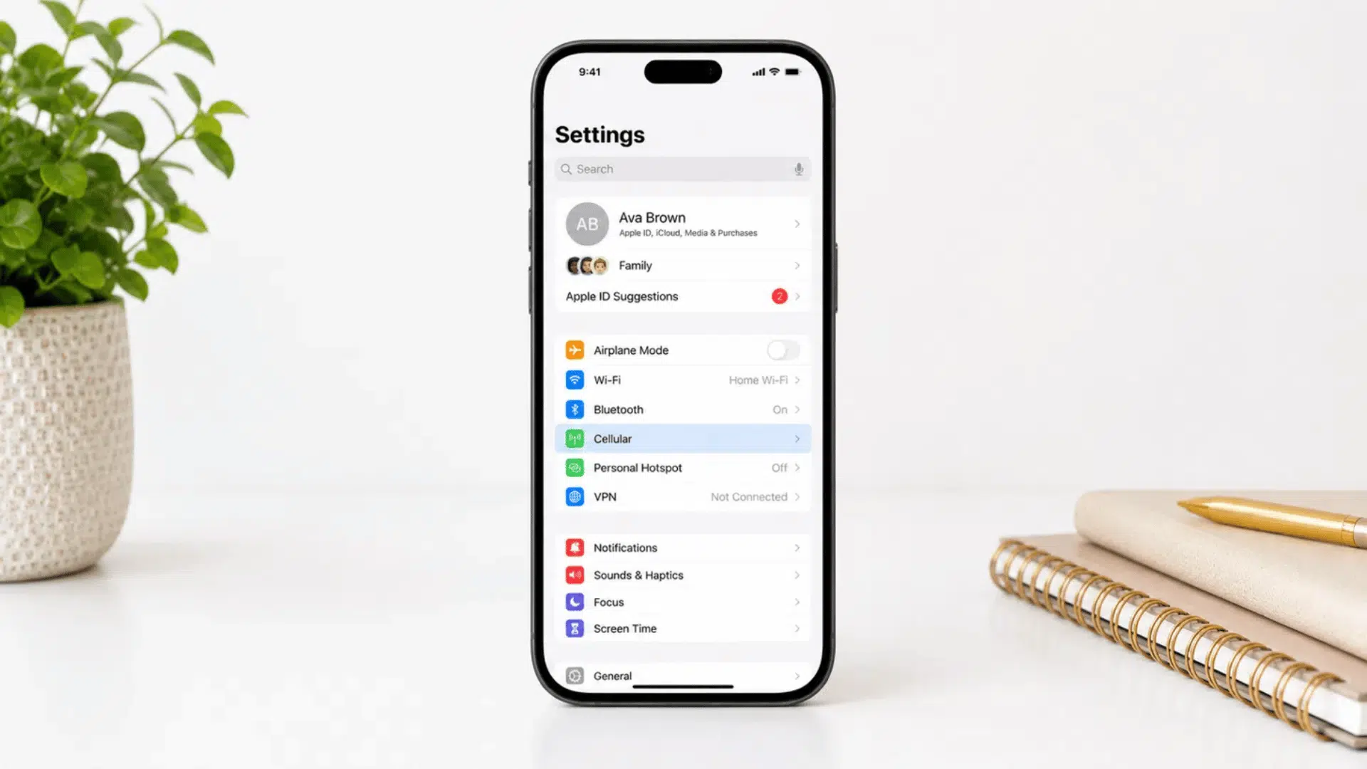 iphone settings screen with cellular option highlighted in blue on white desk