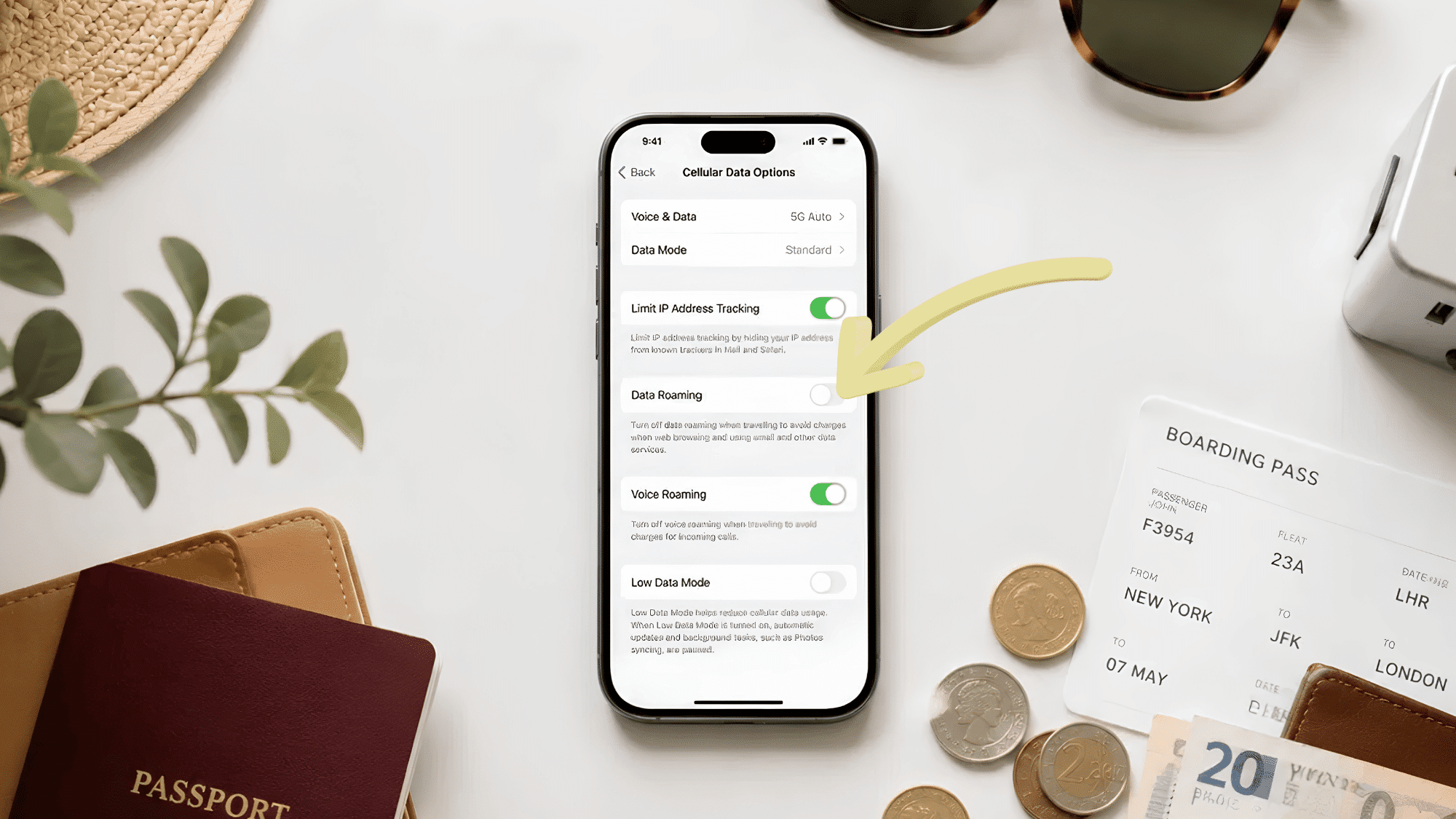 iphone showing data roaming settings off surrounded by passport boarding pass coins and travel adapter (1)