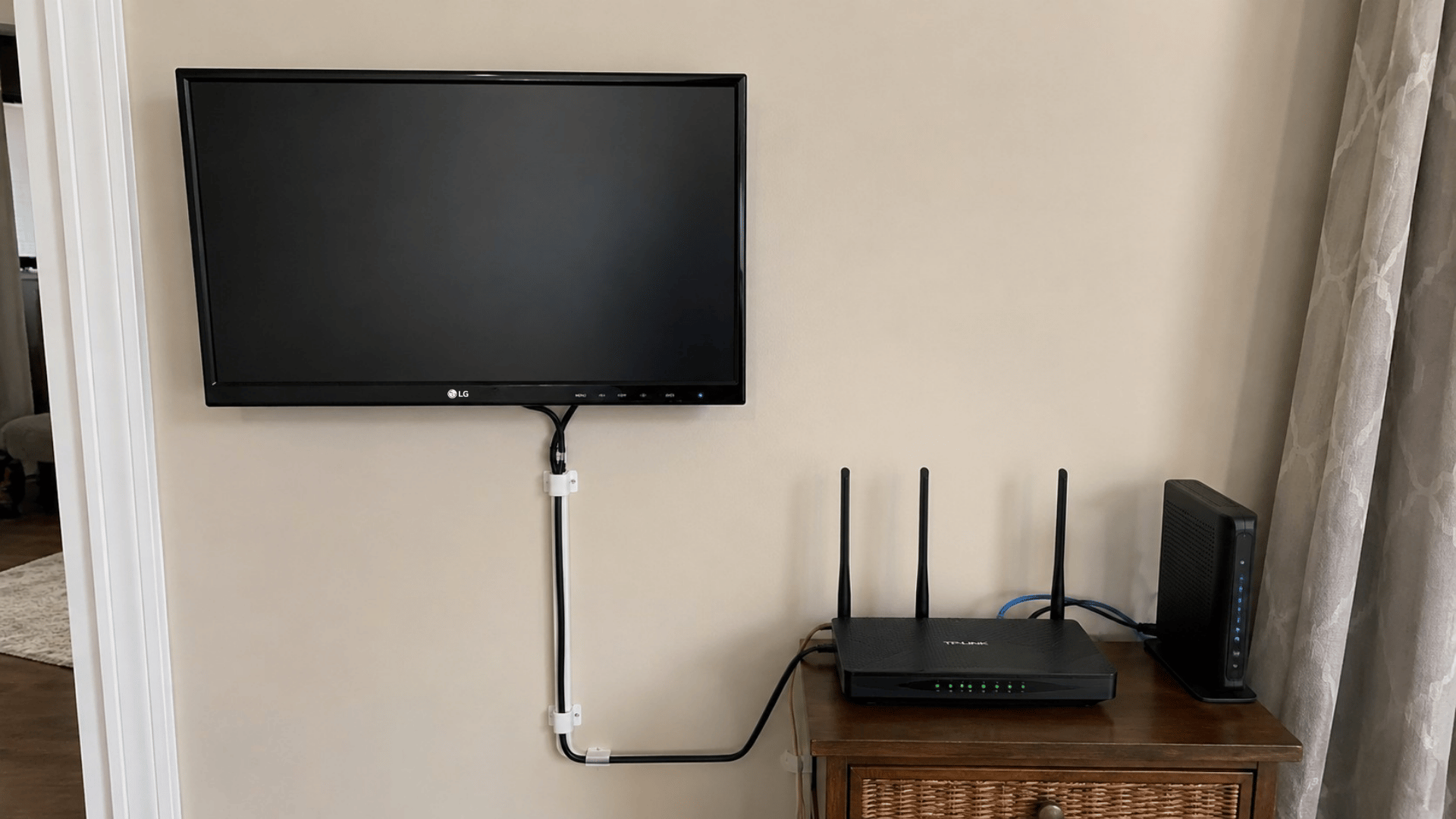 minimal tech setup with router and monitor showing a proper cctv camera feed setup ina n indoor setting with visible home props and background wall