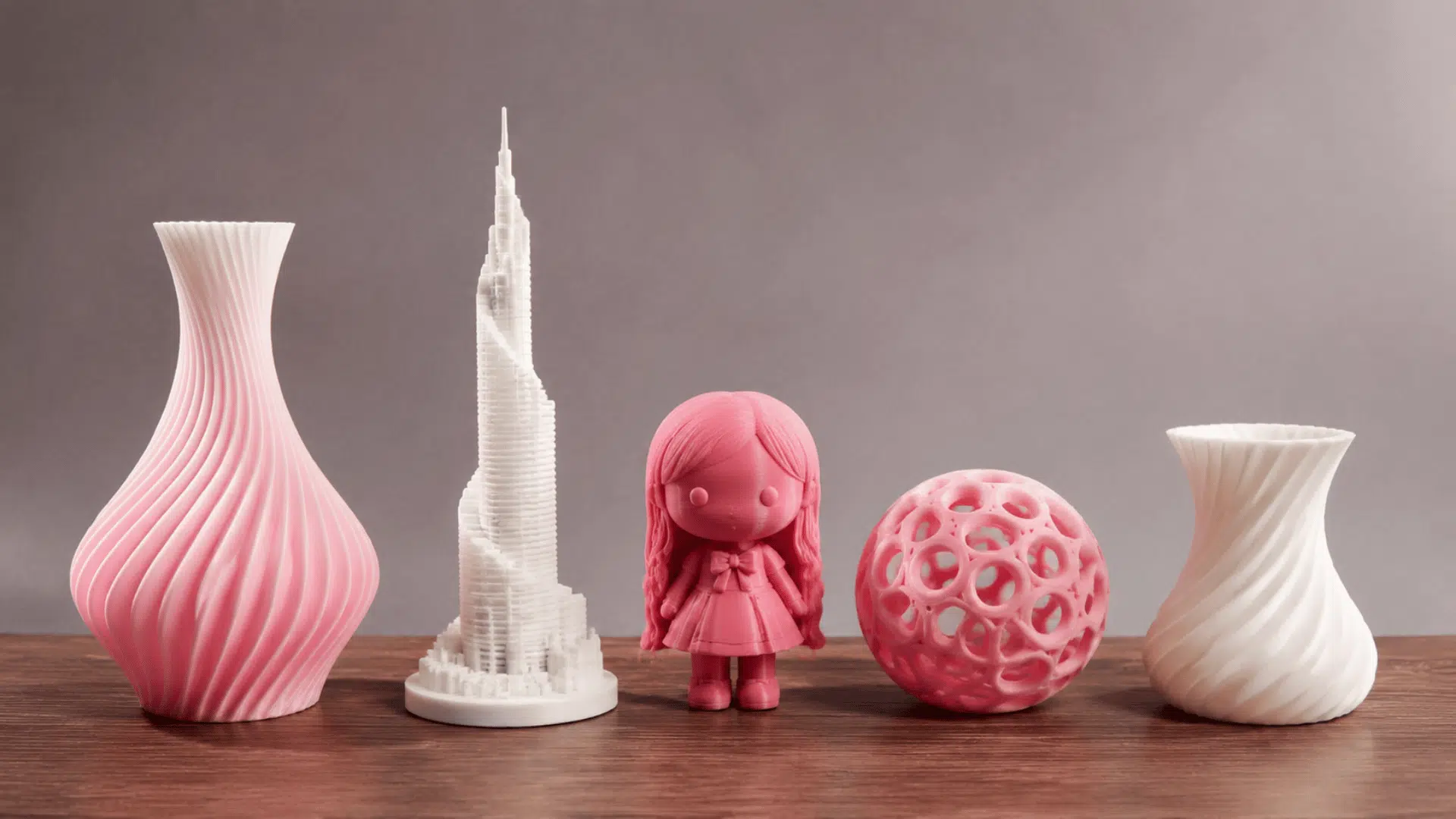 multiple 3d printed structures kept on a table vase tower doll a ball and a curved vase in natural light indoor setting