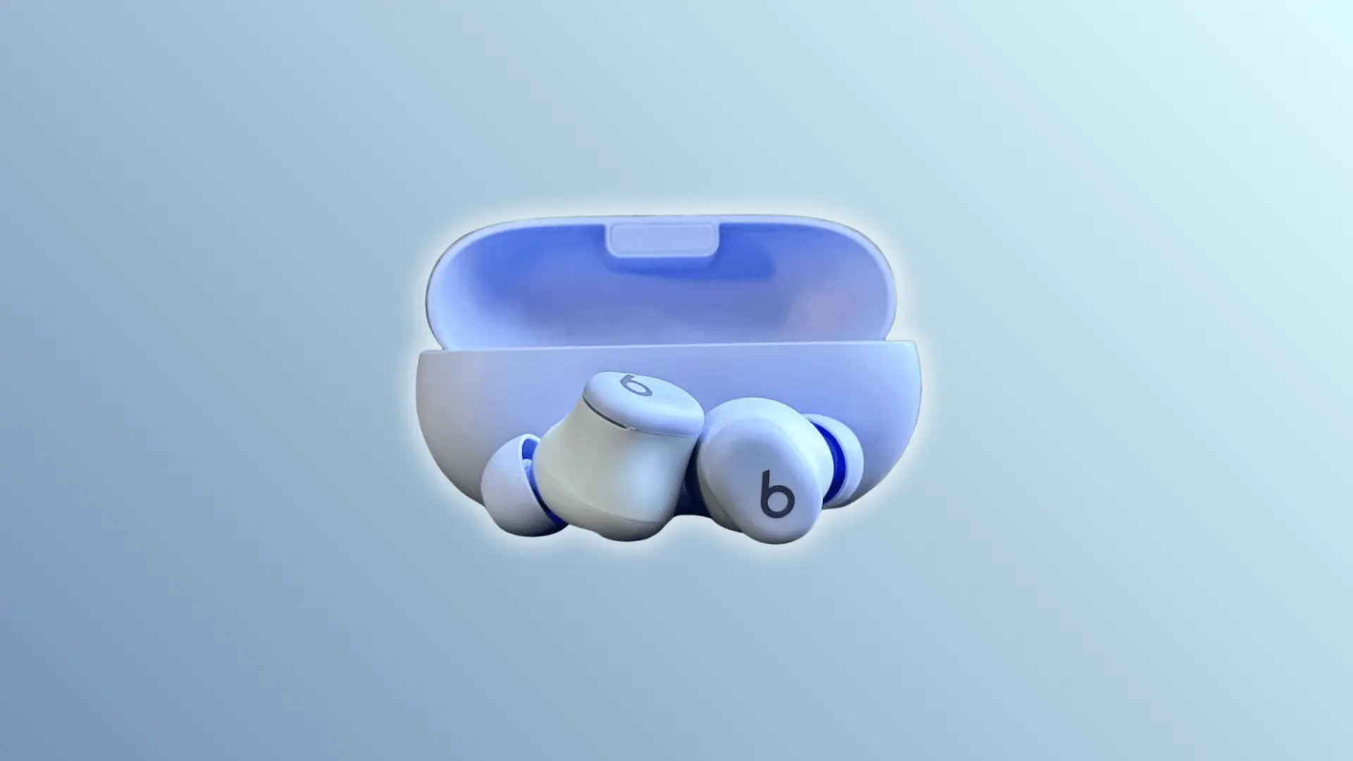 White Beats Solo Buds earbuds in an open charging case on a light blue background.