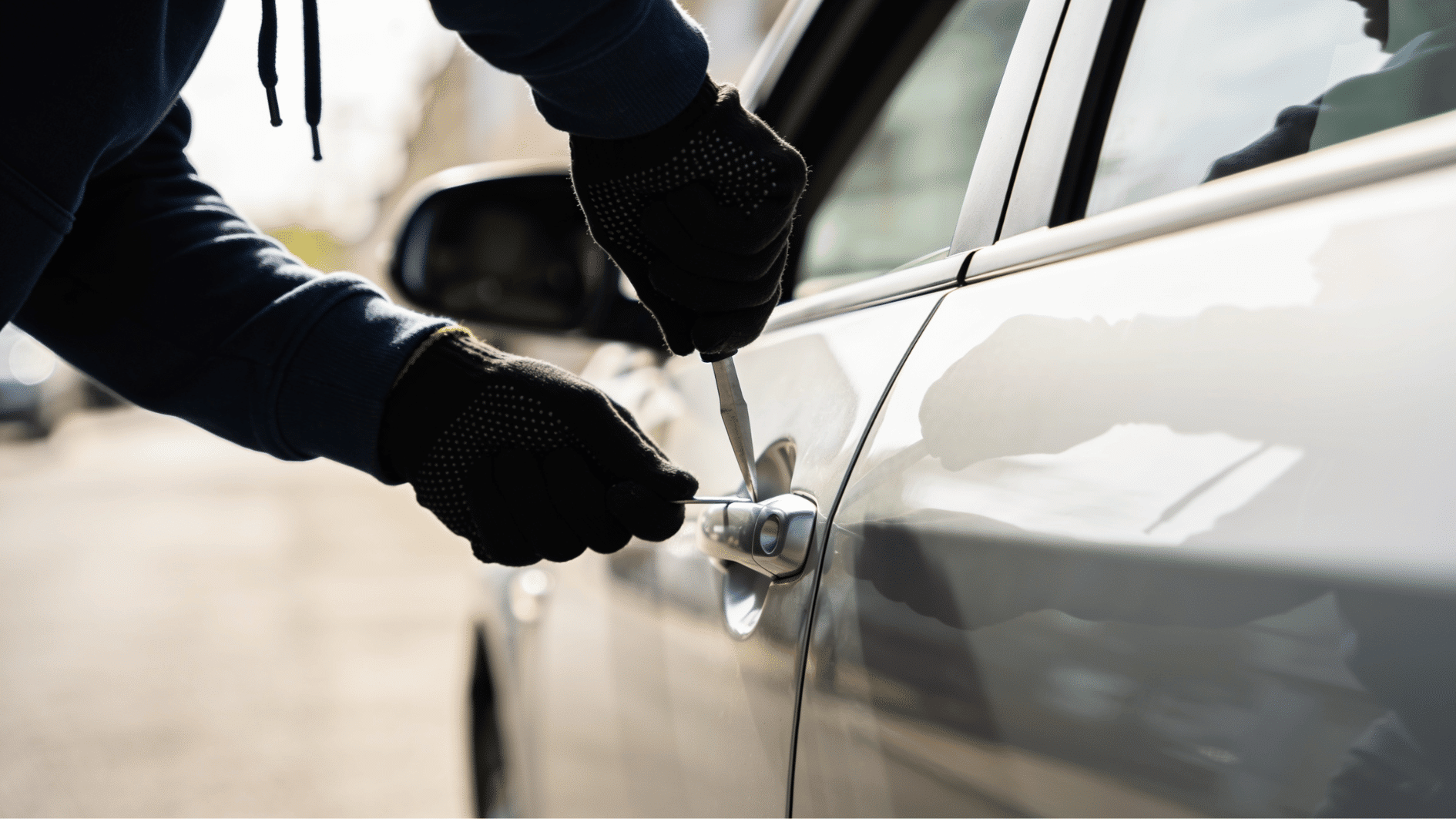 black gloved hands attempting to commit felony by trying to break in a car