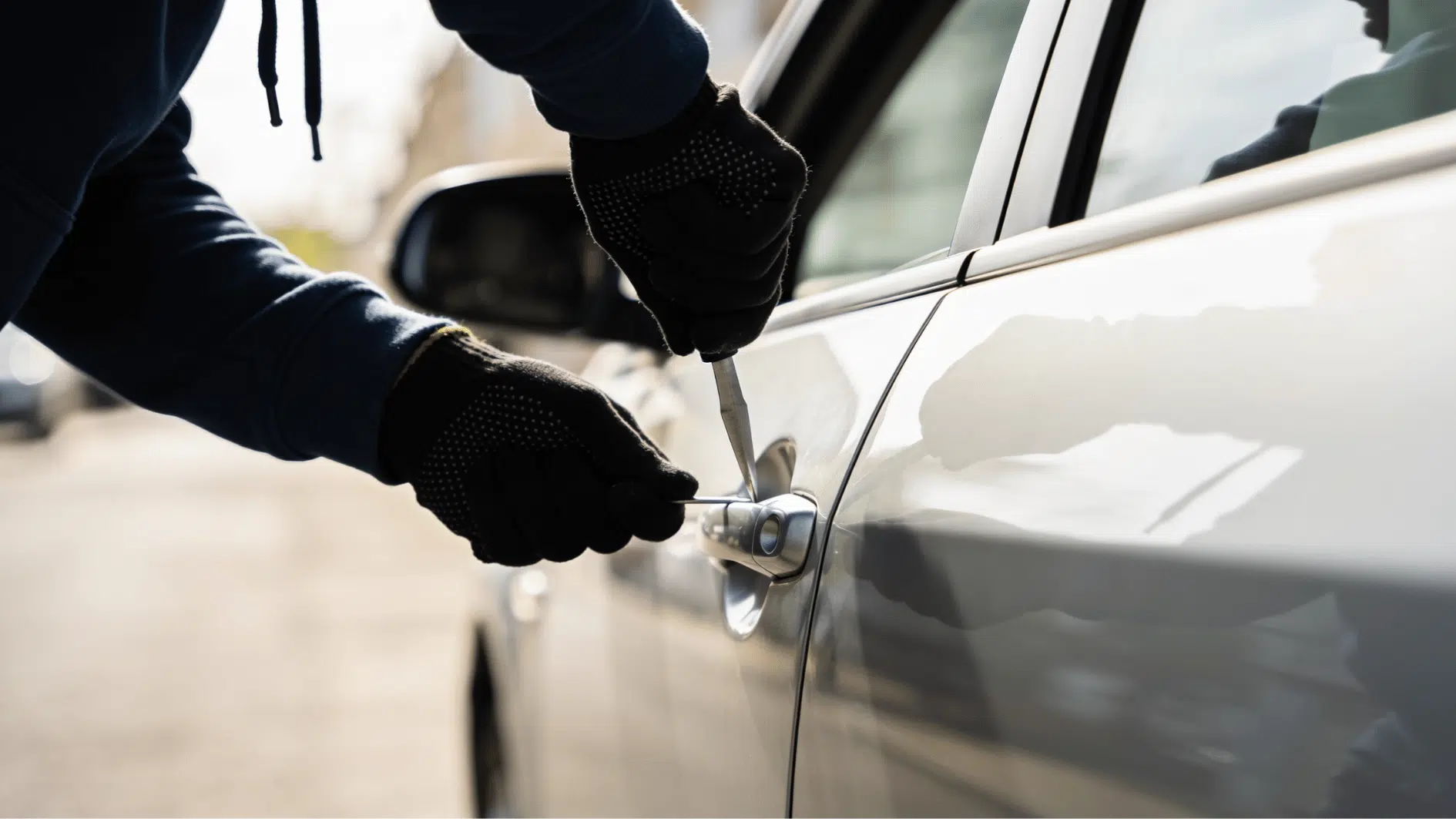 black gloved hands attempting to commit felony by trying to break in a car
