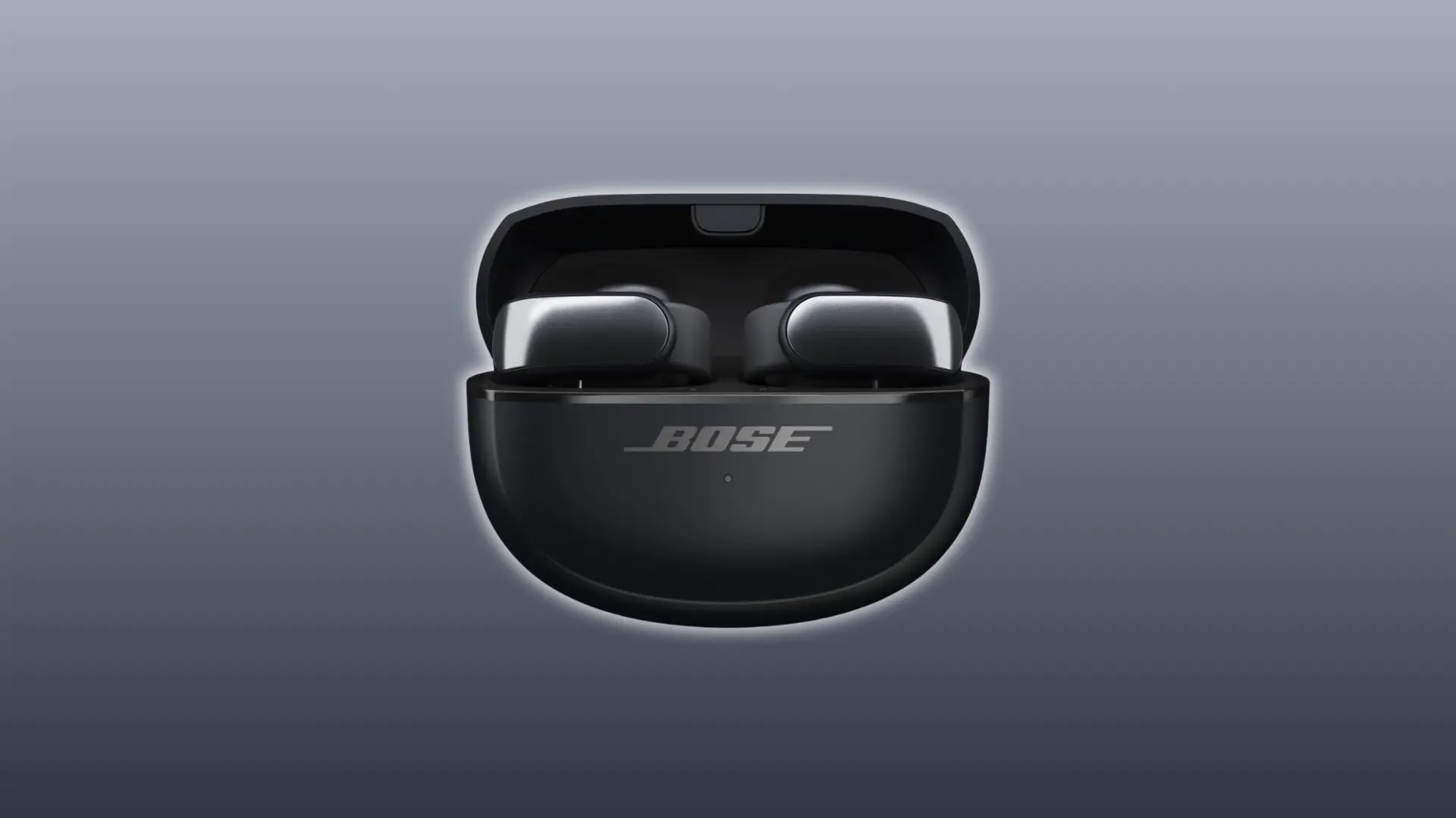Bose Ultra Open Earbuds resting inside their black charging case with the lid open, showing the compact case design and earbuds in place.