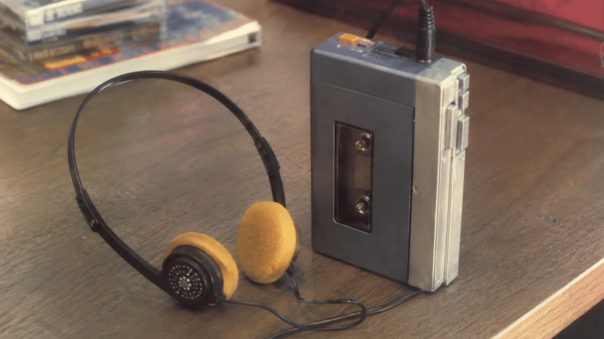 portable on-ear headphones with a cassette player from the 1980s in a faded vintage film photograph