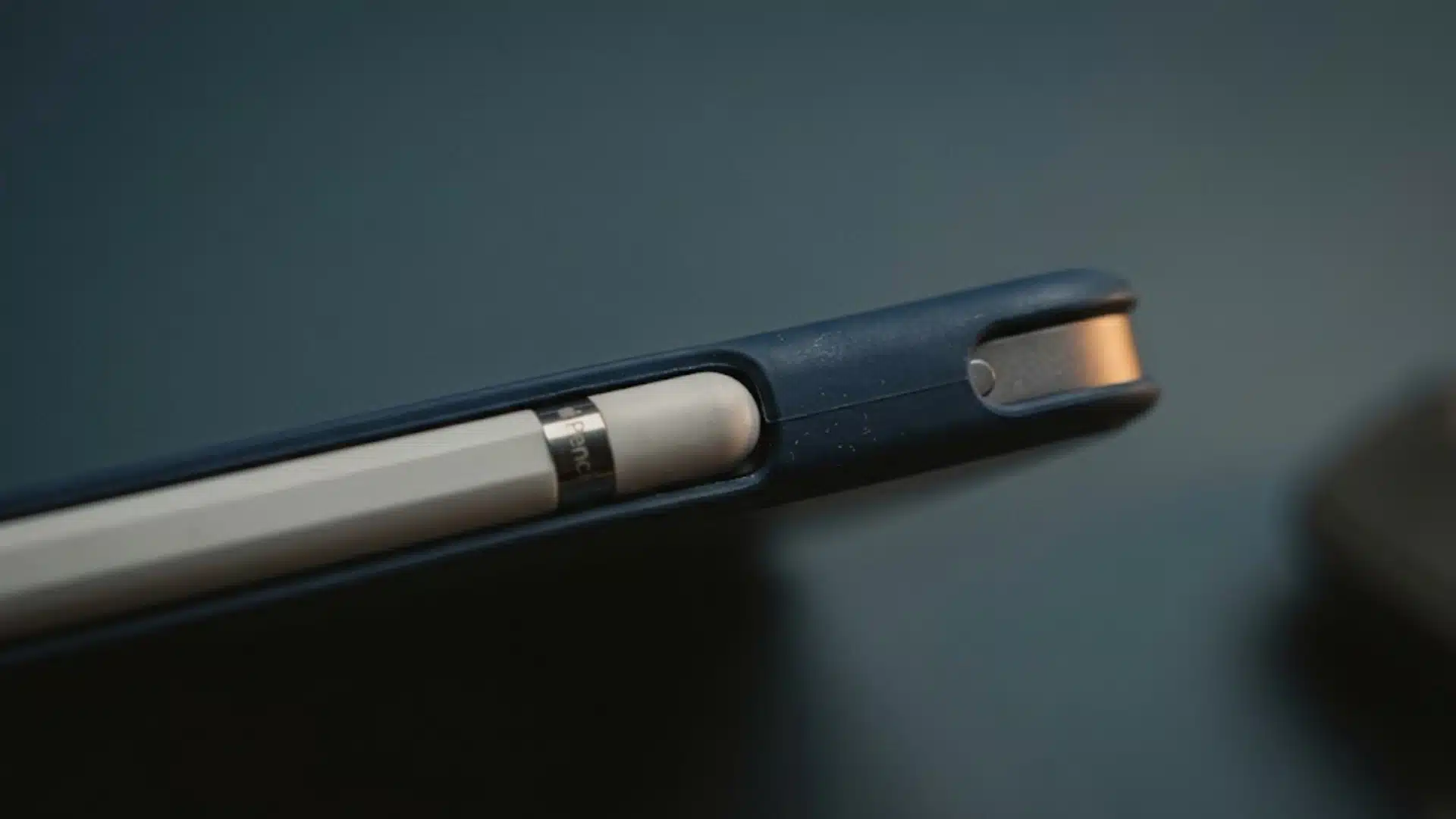 Apple Pencil attached to an iPad's magnetic strip partly blocked by a case edge