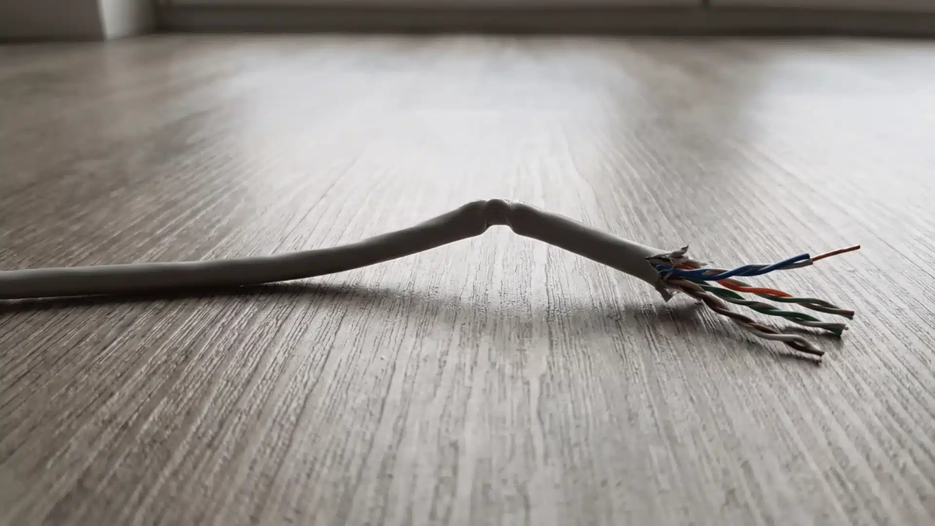 Ethernet cable showing long run with bend and damaged conductor sections