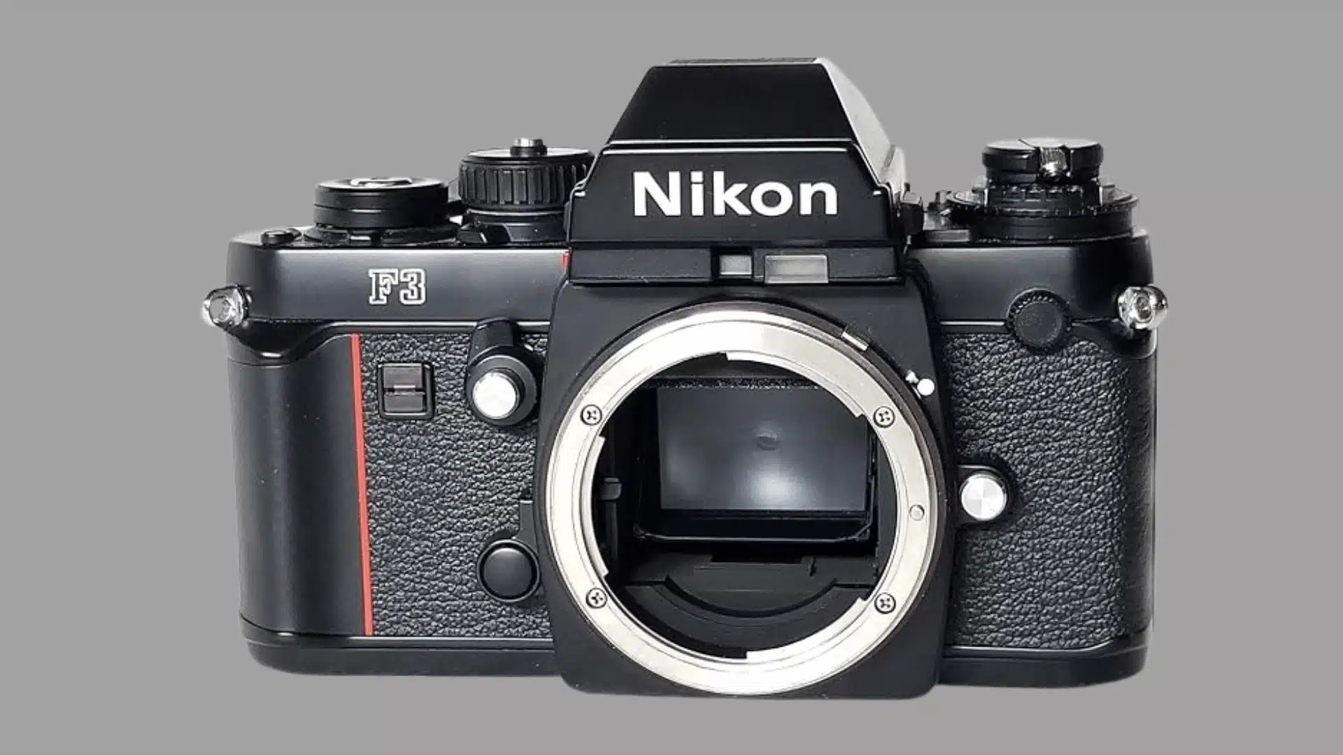 Front view of a black Nikon F3 film camera body without a lens, showing the open lens mount.