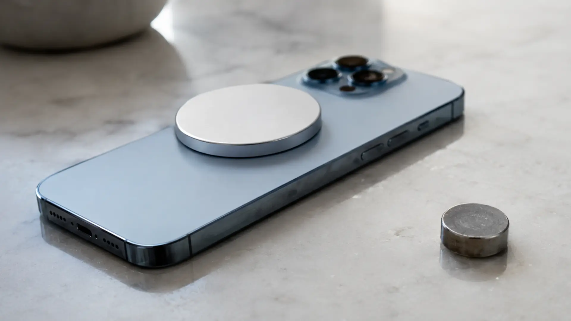 Magnetic accessory attached to the back of a MagSafe iPhone with a regular magnet placed nearby