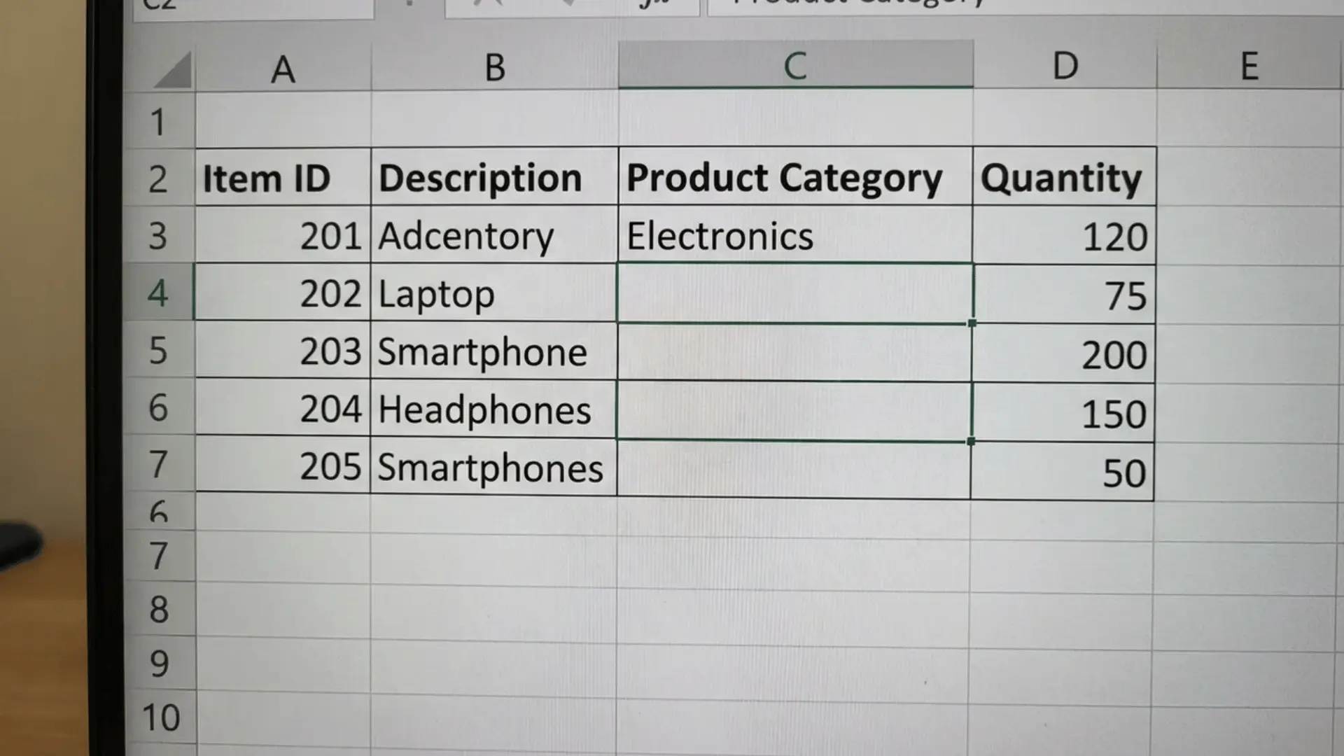 Excel sheet with sample data showing a filled top cell and blank cells after unmerging